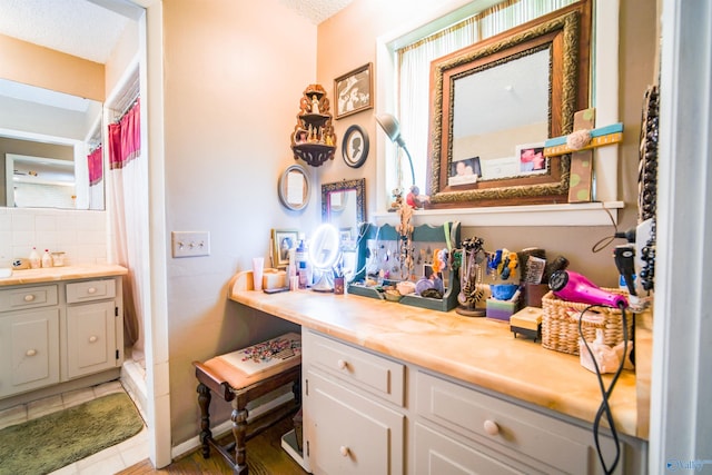 bathroom featuring a textured ceiling, vanity, and tile patterned flooring