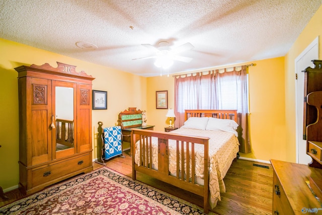 bedroom with ceiling fan, light wood-type flooring, and a textured ceiling