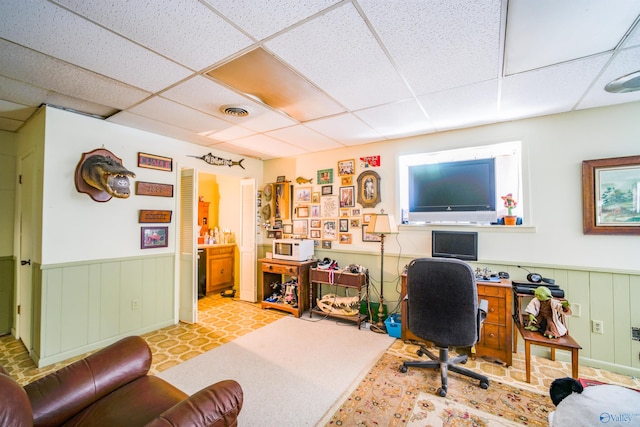 tiled office space featuring a paneled ceiling