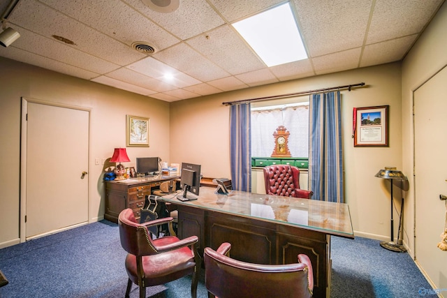 carpeted office space with a paneled ceiling