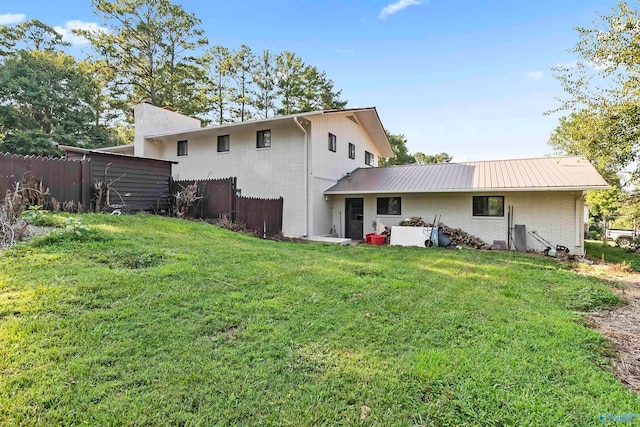 rear view of property with a yard