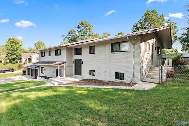 rear view of property with a lawn