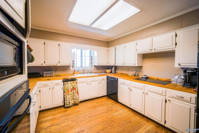 kitchen featuring black appliances, sink, light wood-type flooring, and white cabinetry