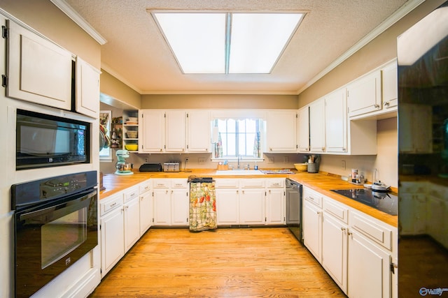 kitchen with black appliances, light hardwood / wood-style flooring, and white cabinets