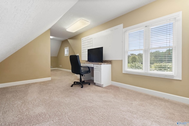 unfurnished office featuring a textured ceiling, light carpet, and lofted ceiling