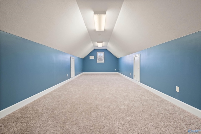 additional living space featuring carpet floors and lofted ceiling