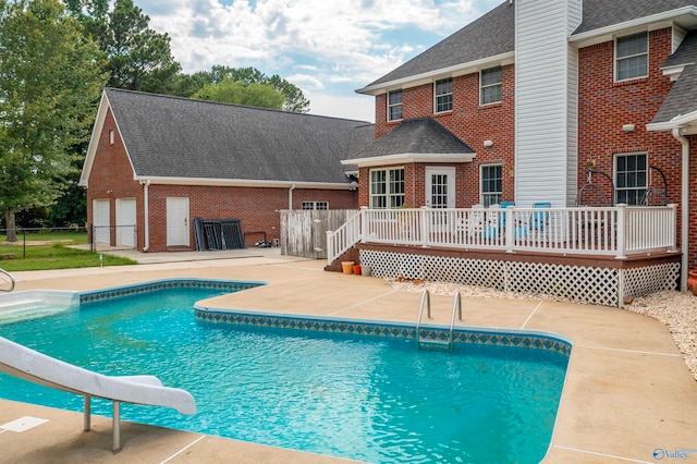 view of swimming pool featuring a water slide and a wooden deck