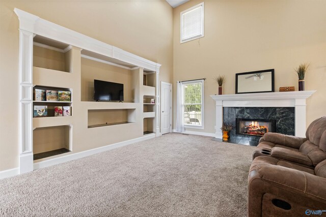 carpeted living room with a fireplace and built in shelves