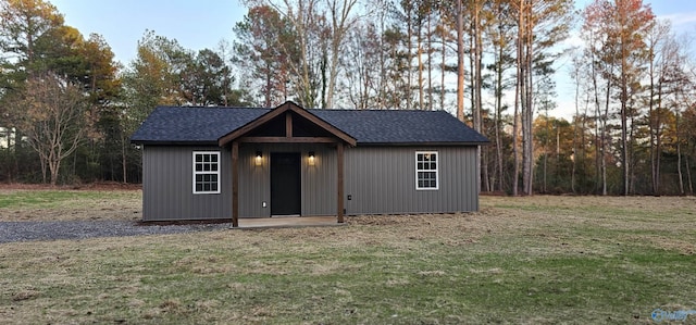 view of front of property featuring a front lawn and an outdoor structure