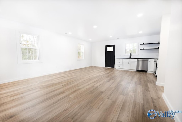 unfurnished living room with light hardwood / wood-style flooring and sink