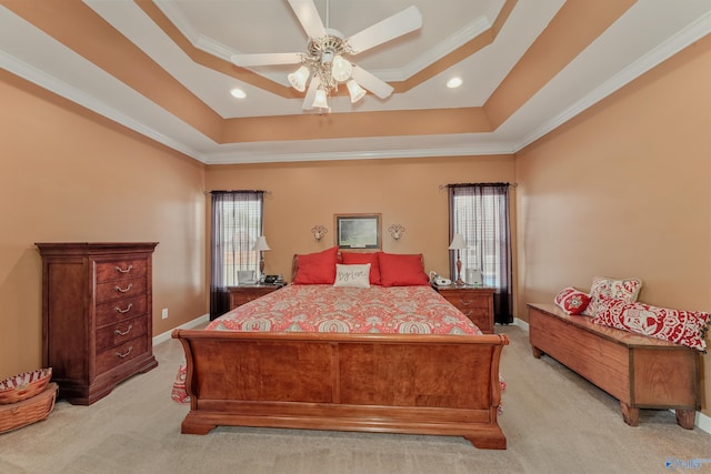 carpeted bedroom featuring ceiling fan, a tray ceiling, crown molding, and multiple windows