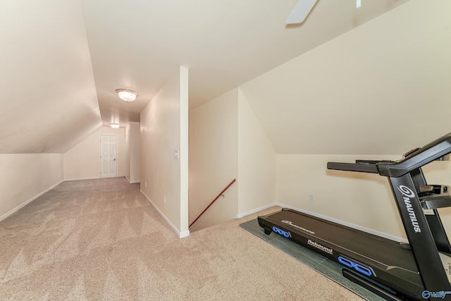 exercise room featuring light carpet, vaulted ceiling, and ceiling fan