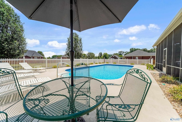 view of swimming pool with a sunroom and a patio