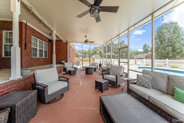 sunroom featuring ceiling fan and a swimming pool