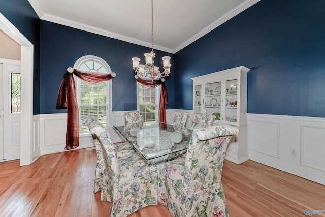 dining room with crown molding, light hardwood / wood-style floors, and a chandelier