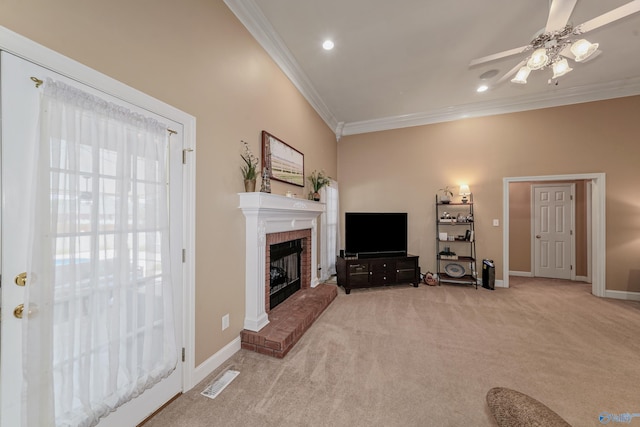 living room featuring crown molding, a fireplace, ceiling fan, and light colored carpet