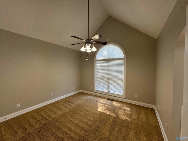 carpeted empty room with ceiling fan and high vaulted ceiling