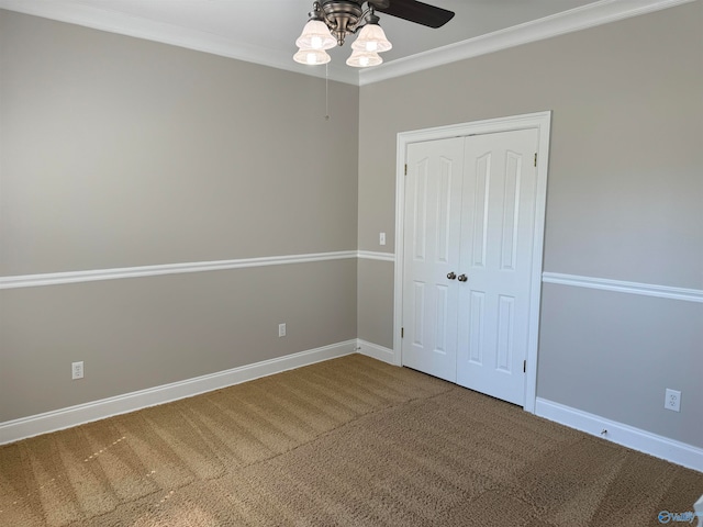 unfurnished bedroom with crown molding, ceiling fan, a closet, and carpet flooring