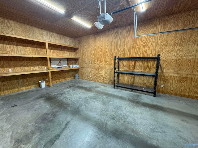 garage with wooden walls and a garage door opener