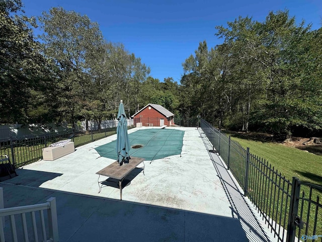 view of pool with an outdoor structure, a lawn, and a patio