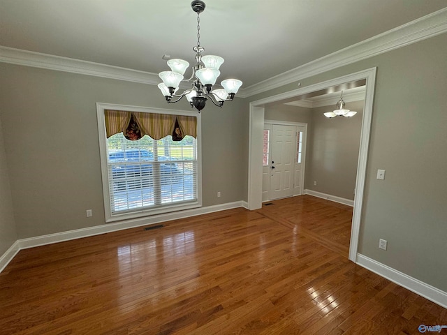 interior space with wood-type flooring, ornamental molding, and an inviting chandelier