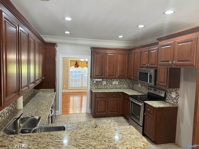 kitchen with light stone countertops, sink, light tile patterned flooring, crown molding, and appliances with stainless steel finishes