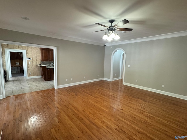 unfurnished room with light hardwood / wood-style floors, ornamental molding, and ceiling fan