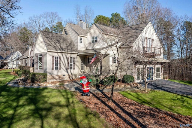 view of front of home featuring a balcony and a front lawn