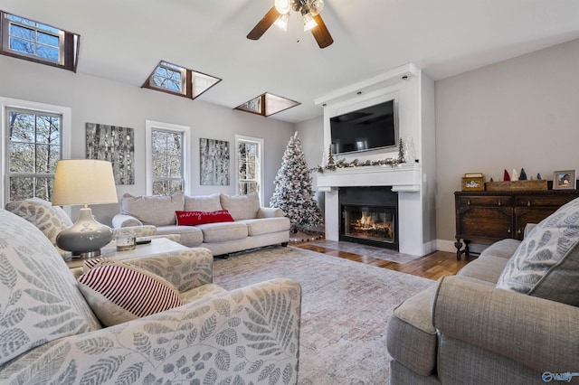 living room with ceiling fan, a fireplace, and light hardwood / wood-style flooring