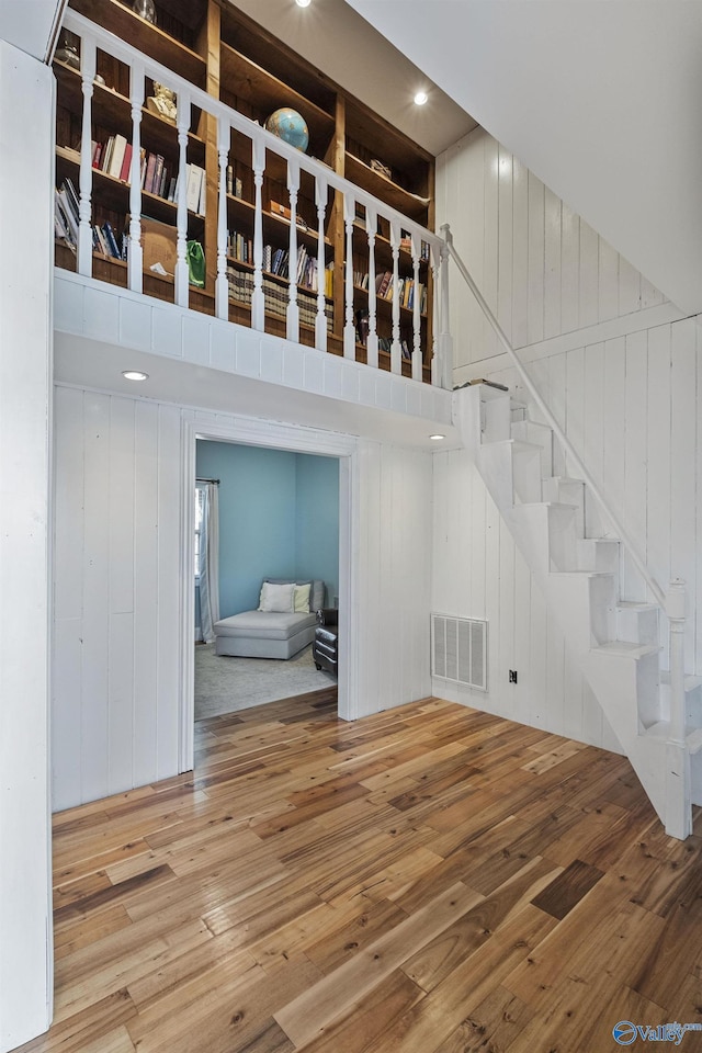 interior space with wooden walls, hardwood / wood-style floors, and a high ceiling