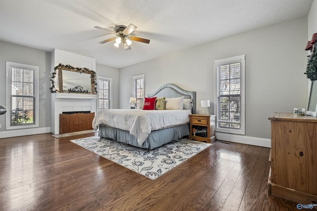 bedroom with ceiling fan, dark hardwood / wood-style flooring, and a textured ceiling