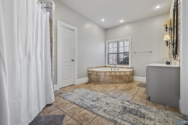 bathroom with tile patterned floors, sink, and tiled tub