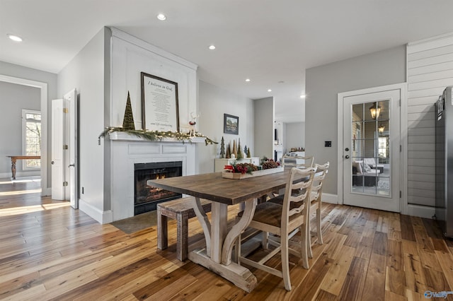 dining room featuring a large fireplace and light wood-type flooring