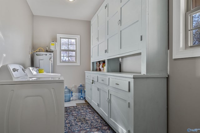 laundry room featuring electric water heater, cabinets, and washer and dryer