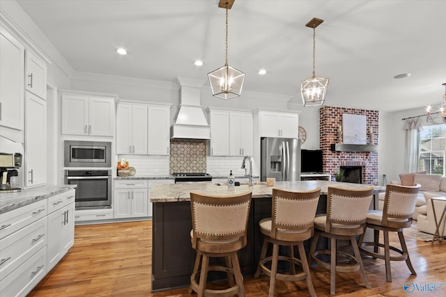 22424 Cantera Dr, Athens, AL 35613 - kitchen with stainless steel appliances, premium range hood, tasteful backsplash, open floor plan, and a breakfast bar
