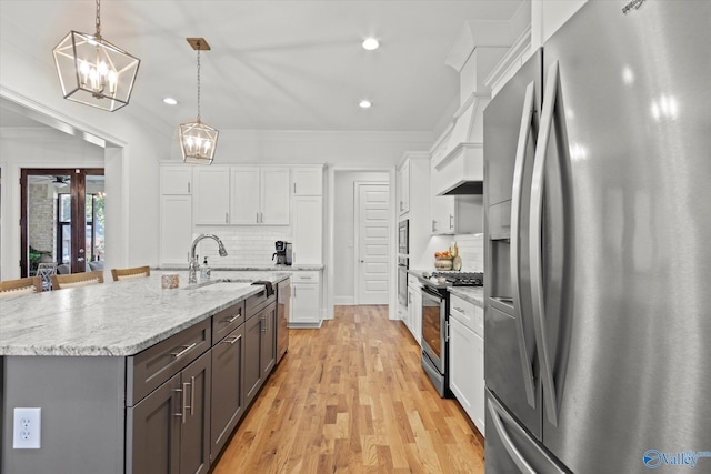 22424 Cantera Dr, Athens, AL 35613 - kitchen with appliances with stainless steel finishes, a chandelier, white cabinets, light wood-style flooring, and a sink