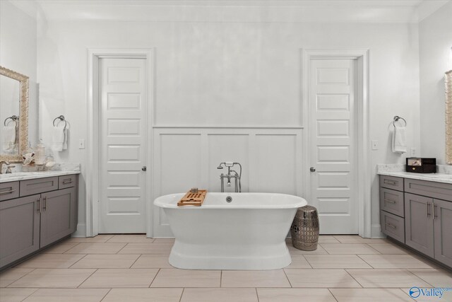 22424 Cantera Dr, Athens, AL 35613 - full bathroom with a freestanding bath, a decorative wall, vanity, and a wainscoted wall