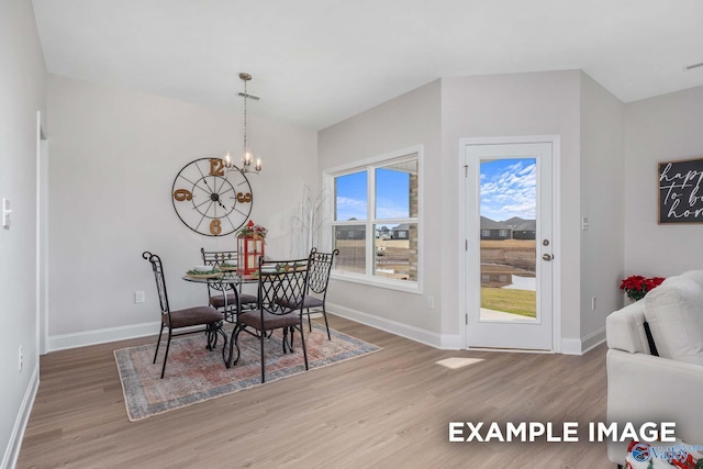 dining space with an inviting chandelier, wood finished floors, visible vents, and baseboards