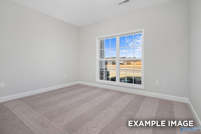 carpeted empty room with visible vents and baseboards