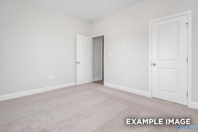 unfurnished bedroom featuring carpet and baseboards