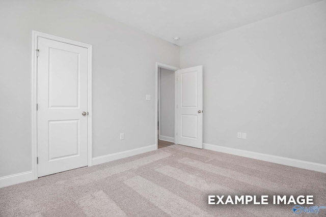 unfurnished bedroom featuring carpet floors and baseboards