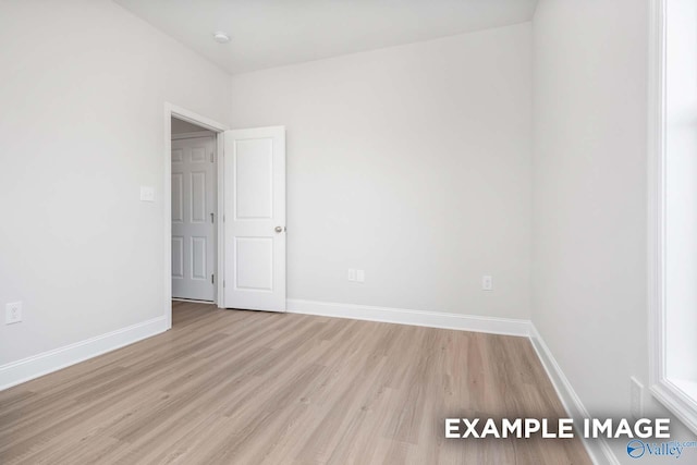 empty room with light wood-style flooring and baseboards