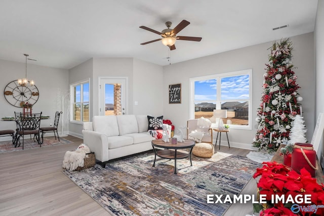 living area featuring plenty of natural light, visible vents, and wood finished floors