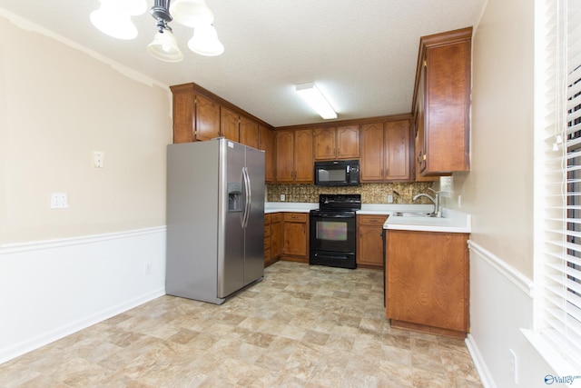 143 Laredo Cir, Huntsville, AL 35811 - kitchen with black appliances, brown cabinetry, a chandelier, a sink, and light countertops