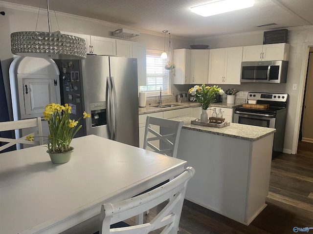 kitchen featuring appliances with stainless steel finishes, white cabinets, a sink, and ornamental molding