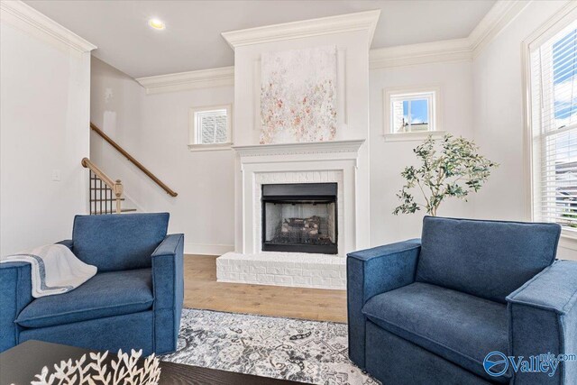 108 Napolean Ave, Madison, AL 35758 - living room featuring crown molding, wood finished floors, plenty of natural light, a brick fireplace, and stairs
