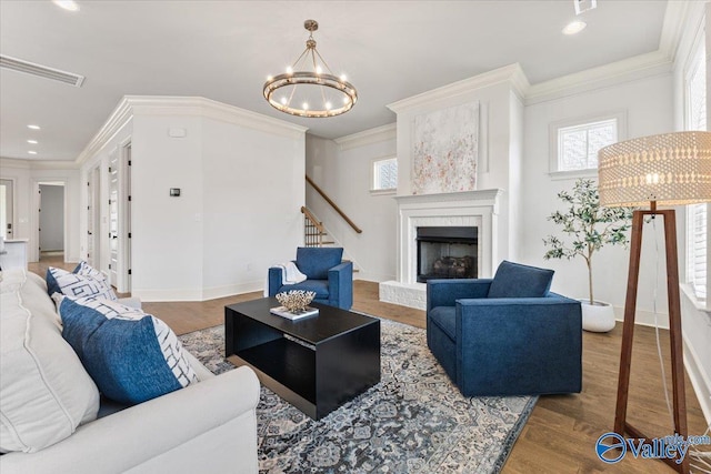108 Napolean Ave, Madison, AL 35758 - living room featuring a chandelier, crown molding, stairway, wood finished floors, and a fireplace