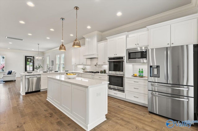 108 Napolean Ave, Madison, AL 35758 - kitchen featuring stainless steel appliances, crown molding, a peninsula, light countertops, and white cabinets