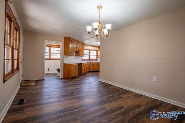 interior space featuring dark wood-type flooring, sink, hanging light fixtures, a textured ceiling, and a chandelier