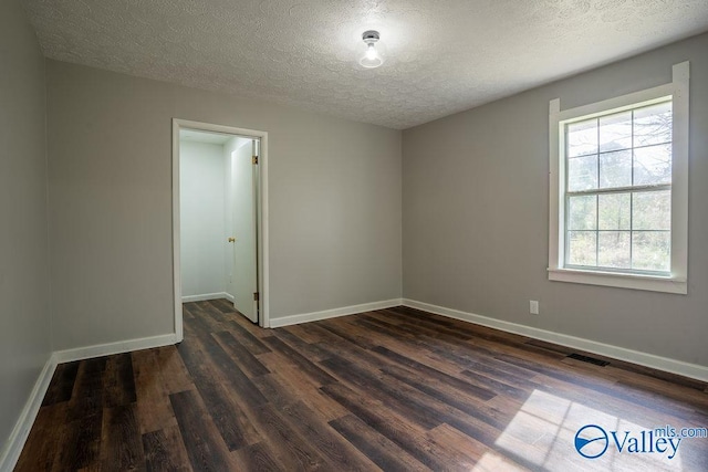 unfurnished room featuring a textured ceiling and dark wood-type flooring